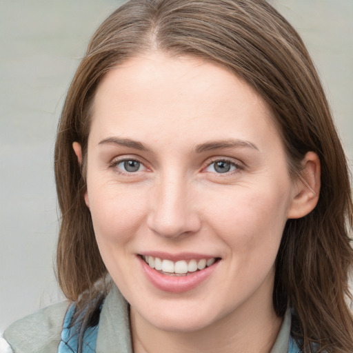 Joyful white young-adult female with long  brown hair and blue eyes