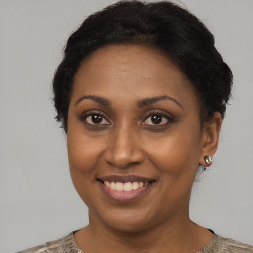 Joyful black young-adult female with short  brown hair and brown eyes