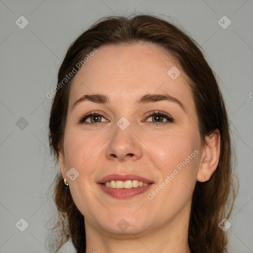 Joyful white adult female with medium  brown hair and green eyes