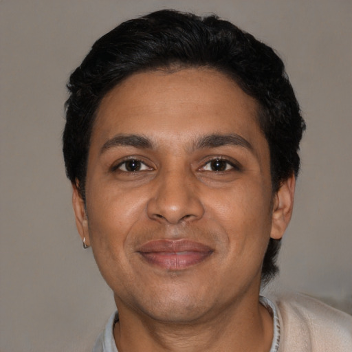 Joyful black adult male with short  black hair and brown eyes
