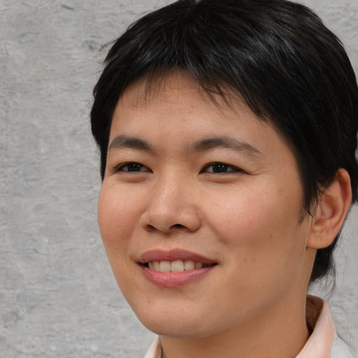 Joyful asian young-adult female with short  brown hair and brown eyes