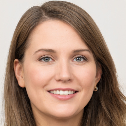 Joyful white young-adult female with long  brown hair and grey eyes