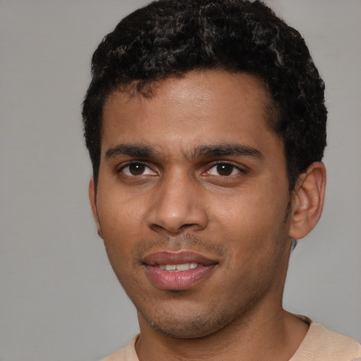 Joyful black young-adult male with short  brown hair and brown eyes