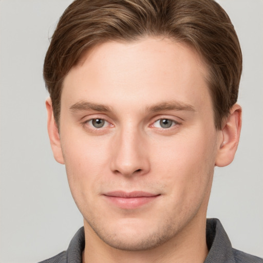 Joyful white young-adult male with short  brown hair and grey eyes