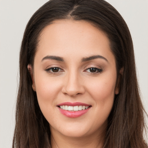 Joyful white young-adult female with long  brown hair and brown eyes