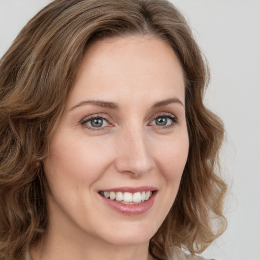 Joyful white young-adult female with medium  brown hair and green eyes