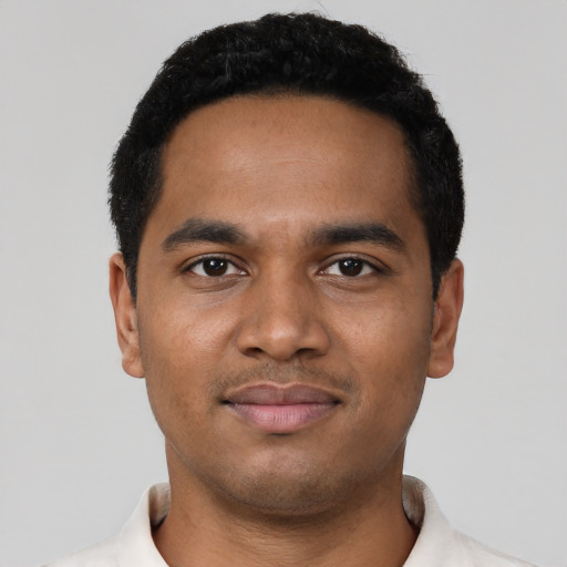 Joyful black young-adult male with short  black hair and brown eyes