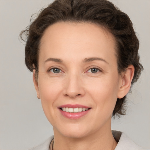 Joyful white adult female with medium  brown hair and grey eyes