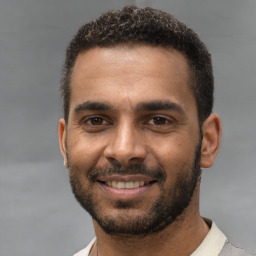 Joyful black young-adult male with short  black hair and brown eyes