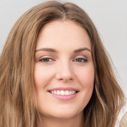 Joyful white young-adult female with long  brown hair and green eyes