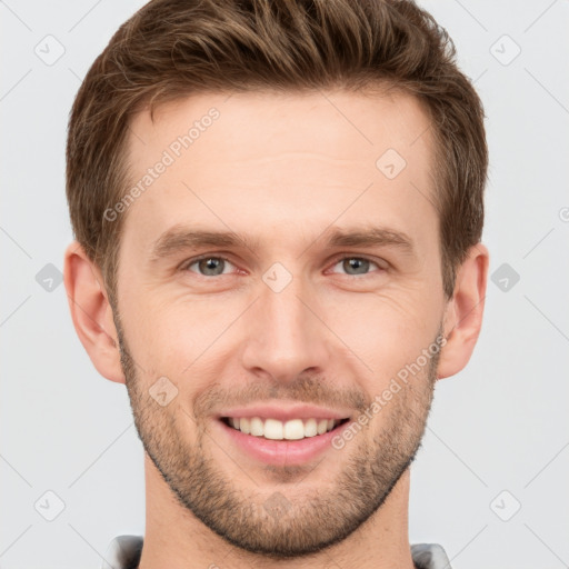 Joyful white young-adult male with short  brown hair and grey eyes