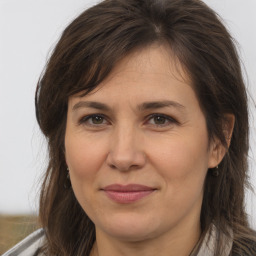 Joyful white adult female with long  brown hair and brown eyes