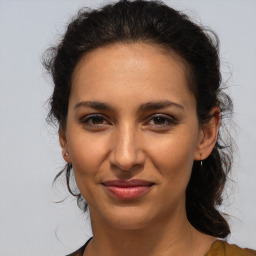 Joyful latino young-adult female with medium  brown hair and brown eyes