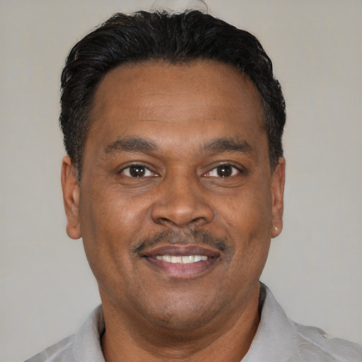 Joyful latino adult male with short  black hair and brown eyes