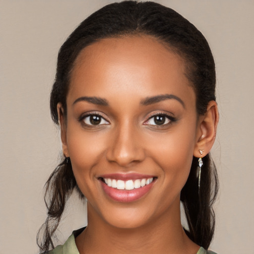 Joyful black young-adult female with medium  brown hair and brown eyes