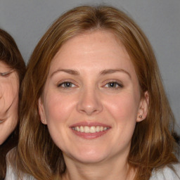 Joyful white adult female with medium  brown hair and brown eyes