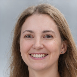 Joyful white young-adult female with long  brown hair and grey eyes