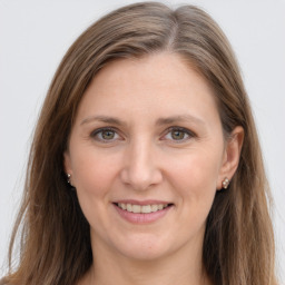 Joyful white young-adult female with long  brown hair and grey eyes