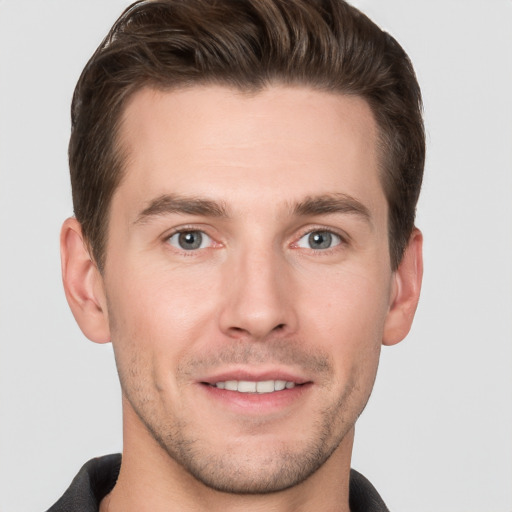 Joyful white young-adult male with short  brown hair and grey eyes