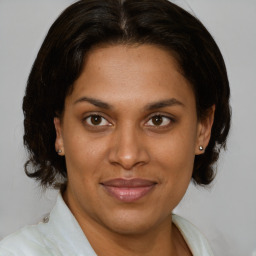 Joyful latino adult female with medium  brown hair and brown eyes