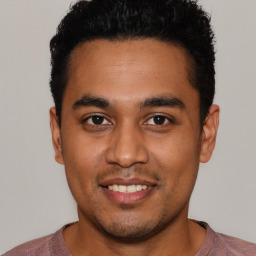 Joyful latino young-adult male with short  black hair and brown eyes