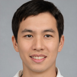 Joyful asian young-adult male with short  brown hair and brown eyes