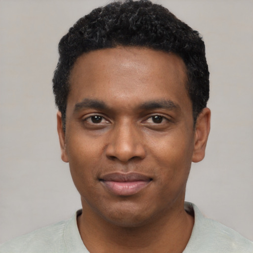 Joyful black young-adult male with short  black hair and brown eyes