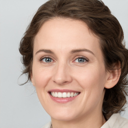 Joyful white young-adult female with medium  brown hair and green eyes