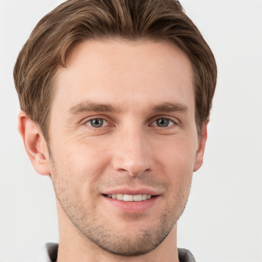 Joyful white young-adult male with short  brown hair and grey eyes