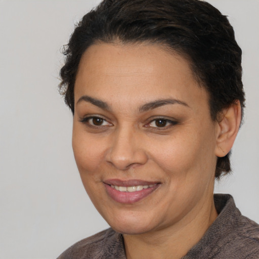 Joyful latino young-adult female with short  brown hair and brown eyes