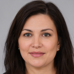 Joyful white adult female with long  brown hair and brown eyes