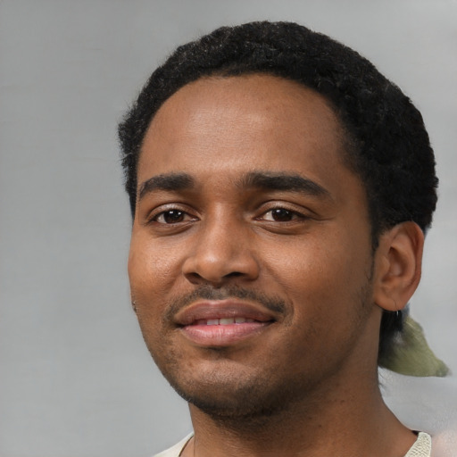 Joyful black young-adult male with short  black hair and brown eyes
