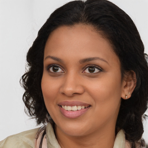 Joyful black young-adult female with long  brown hair and brown eyes
