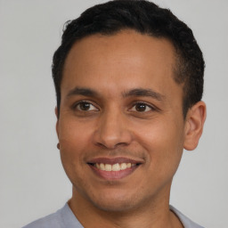 Joyful latino young-adult male with short  brown hair and brown eyes