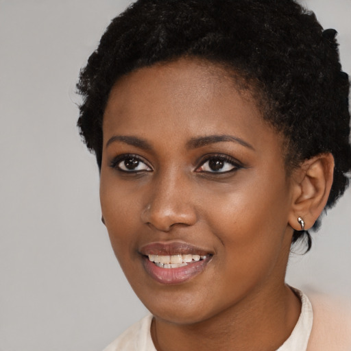 Joyful black young-adult female with short  black hair and brown eyes