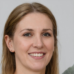 Joyful white young-adult female with medium  brown hair and green eyes