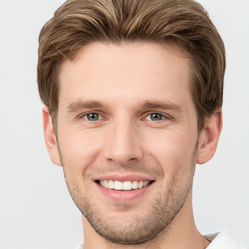 Joyful white young-adult male with short  brown hair and grey eyes