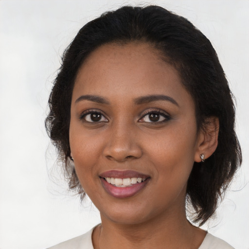 Joyful black young-adult female with long  brown hair and brown eyes