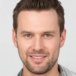 Joyful white young-adult male with short  brown hair and grey eyes