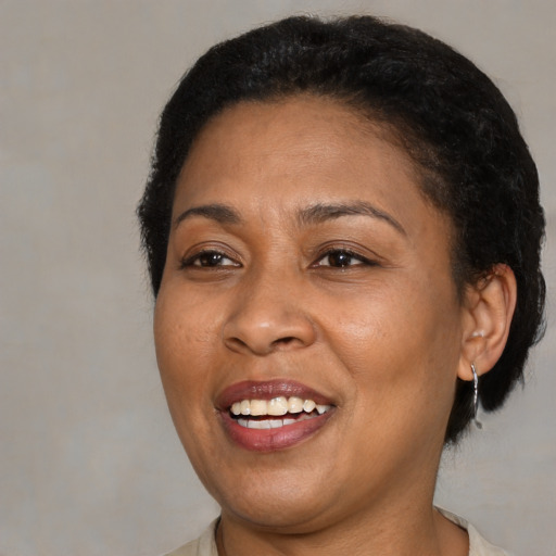 Joyful black adult female with medium  brown hair and brown eyes