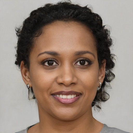 Joyful black young-adult female with short  brown hair and brown eyes