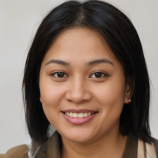 Joyful latino young-adult female with medium  brown hair and brown eyes