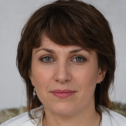 Joyful white adult female with medium  brown hair and grey eyes