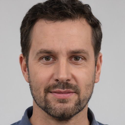 Joyful white adult male with short  brown hair and brown eyes