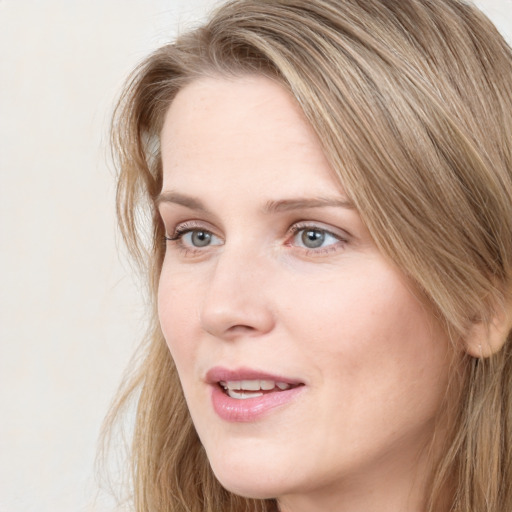 Joyful white young-adult female with long  brown hair and blue eyes