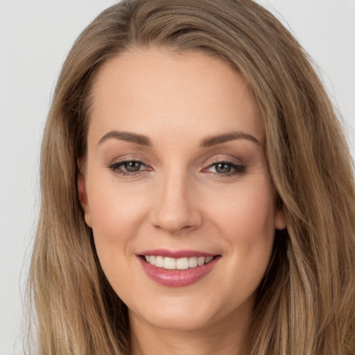 Joyful white young-adult female with long  brown hair and brown eyes