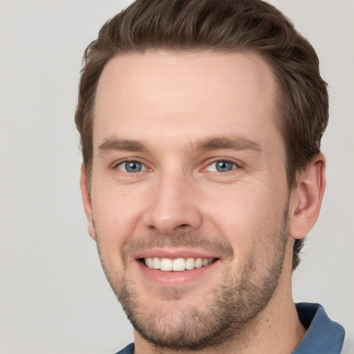 Joyful white young-adult male with short  brown hair and grey eyes