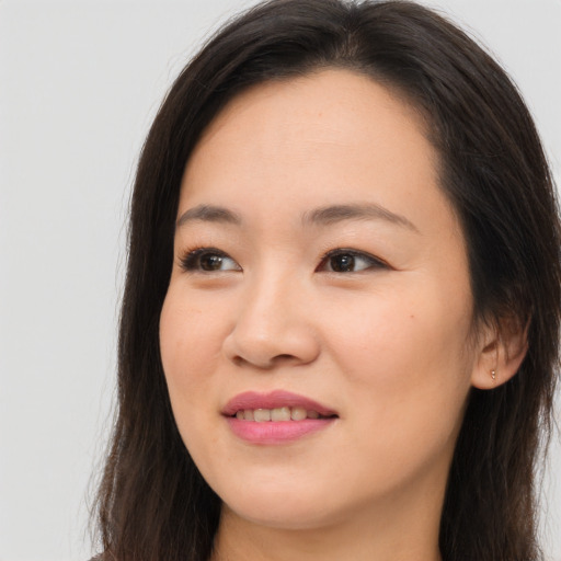 Joyful asian young-adult female with long  brown hair and brown eyes