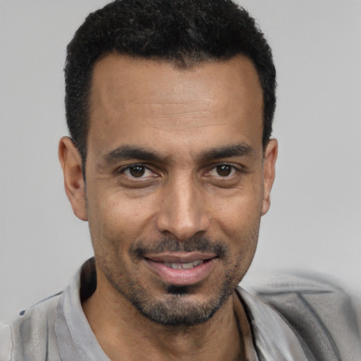 Joyful black young-adult male with short  black hair and brown eyes