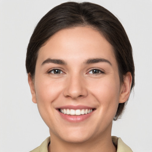 Joyful white young-adult female with medium  brown hair and brown eyes